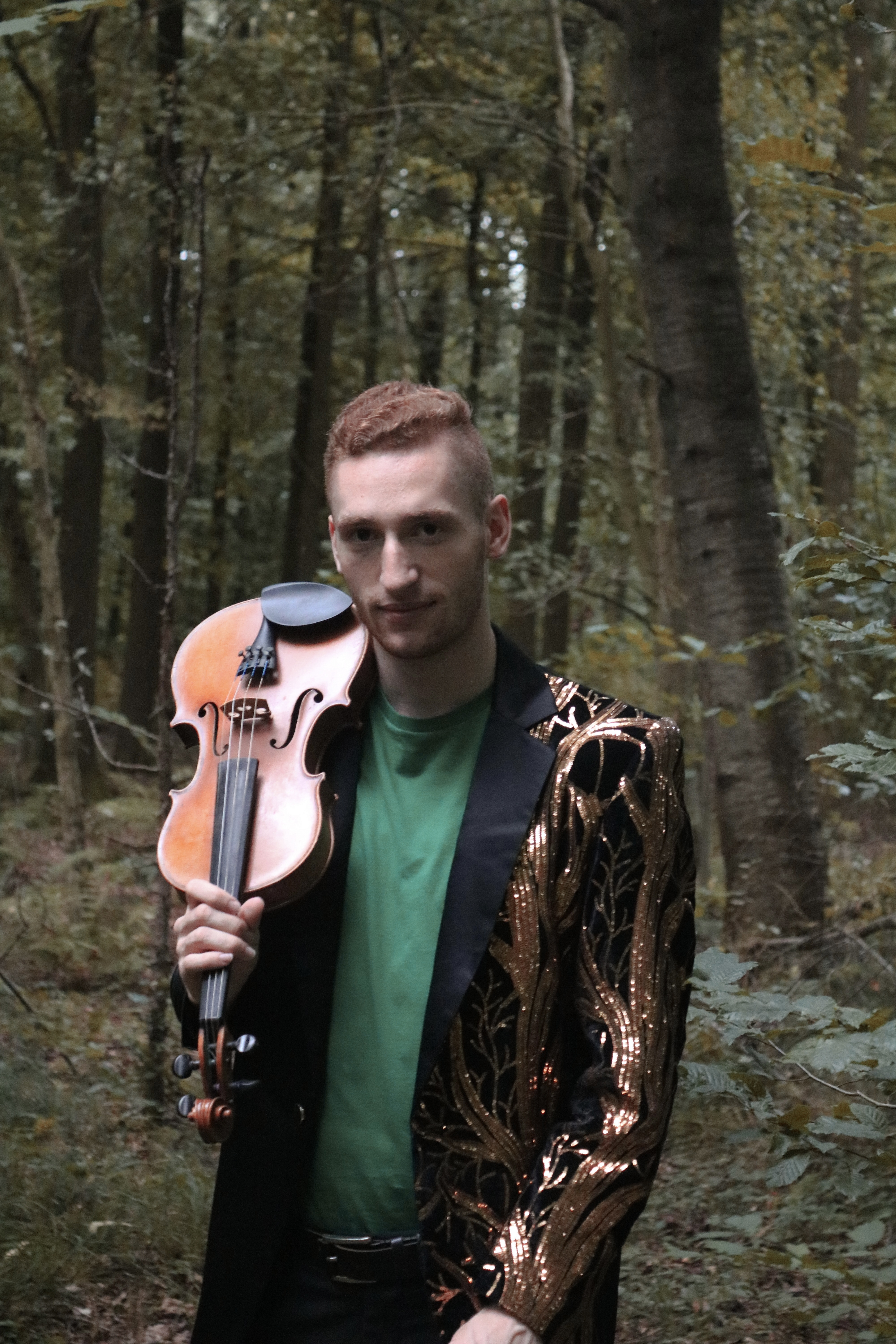 Paul Kolodziej, violinist and musical artist, in the forrest with his violin. Photoshooting for the cover of Wicked Defying Gravity
