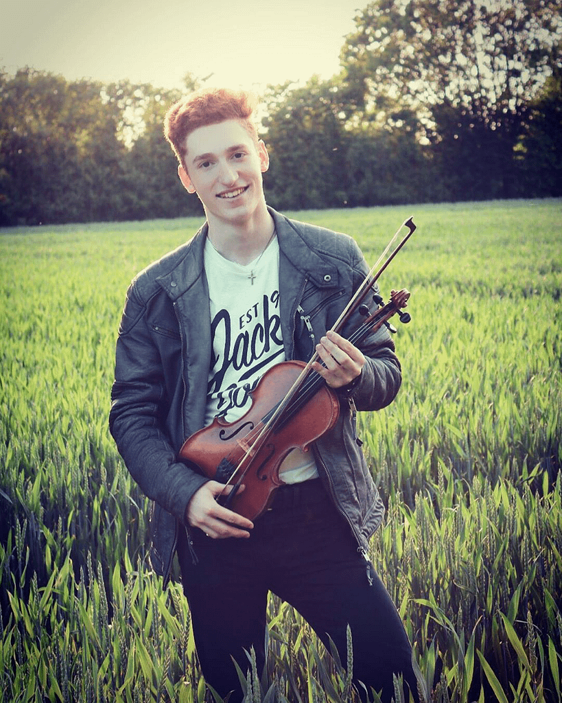 Paul Kolodziej Profilbild, Violinist, im Feld stehend mit seiner Geige
